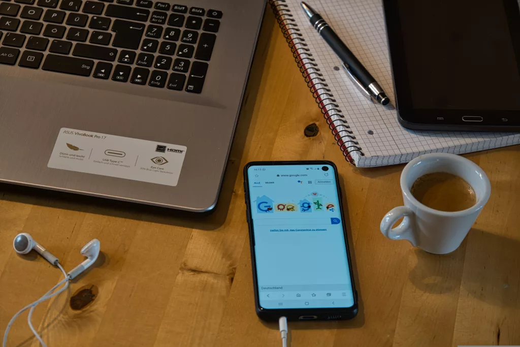 Zu sehen Laptop und ein Handy auf einem Schreibtisch